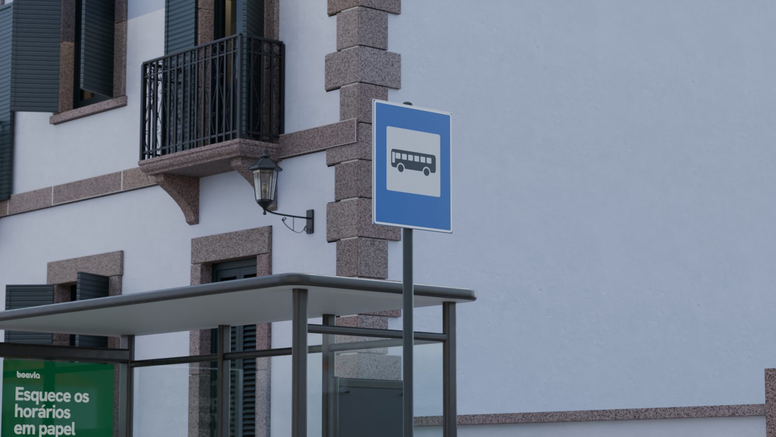 Sinal de paragem à beira da rua, com as casas da vila atrás.